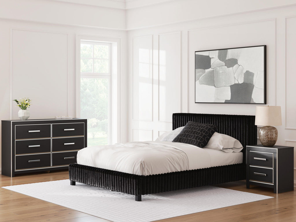 Black upholstered bed with two nightstands and matching dresser