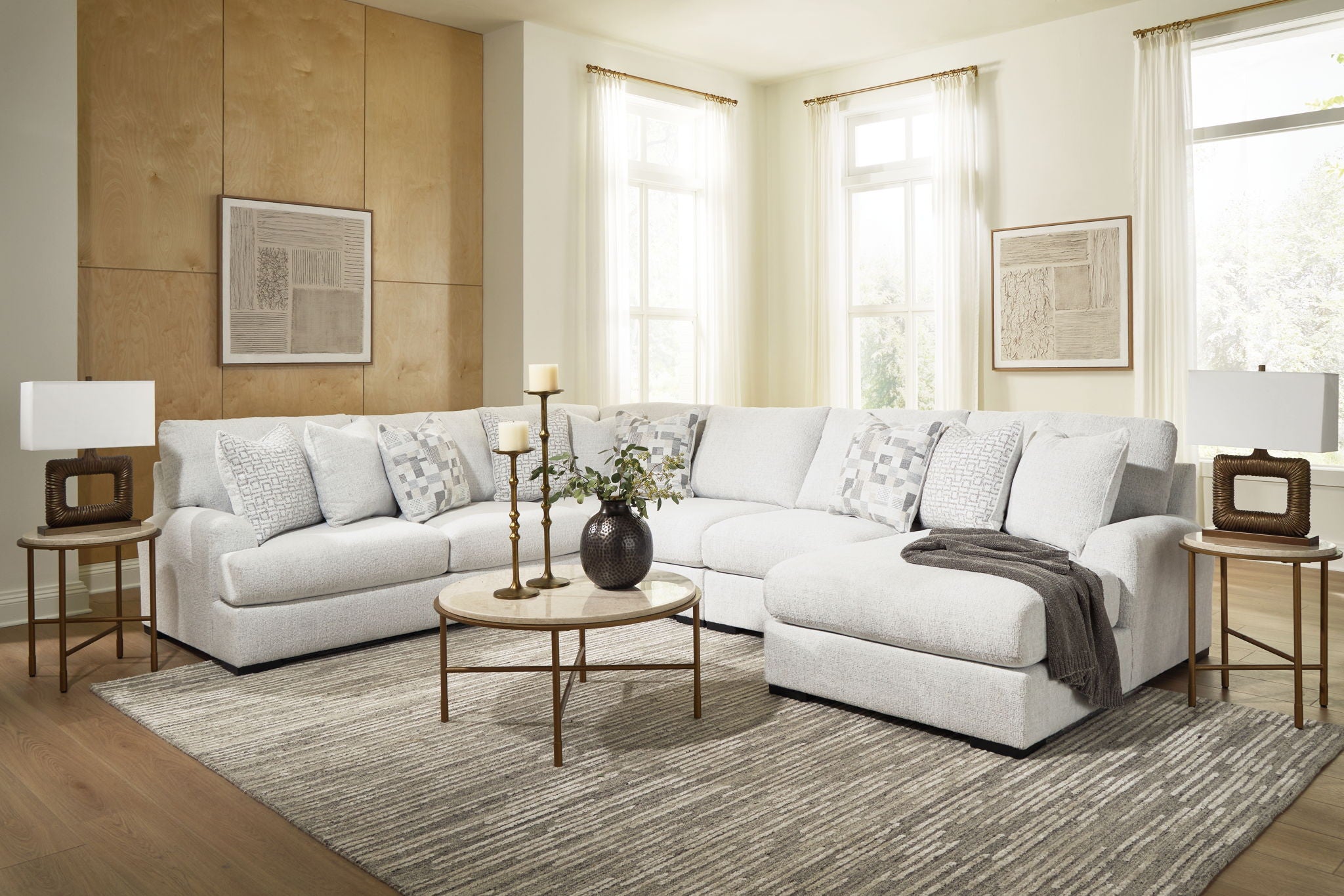 Light beige sectional sofa with chaise bed-like chaise section and patterned pillows