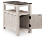 Chair side end table in whitewashed wood with open shelf and open cabinet door