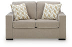 Beige-gray upholstered loveseat with two geometric accent pillows and low arms