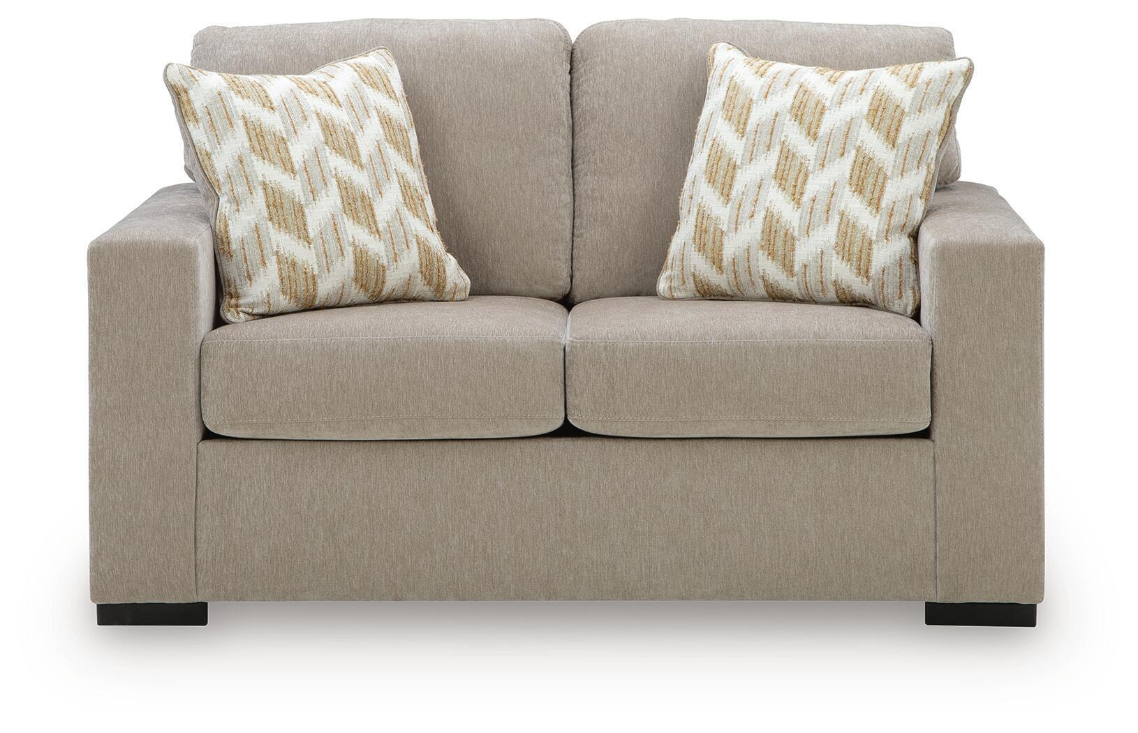 Beige-gray upholstered loveseat with two geometric accent pillows and low arms