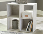 Whitewashed wood cube organizer with open cubbies for books and storage bins