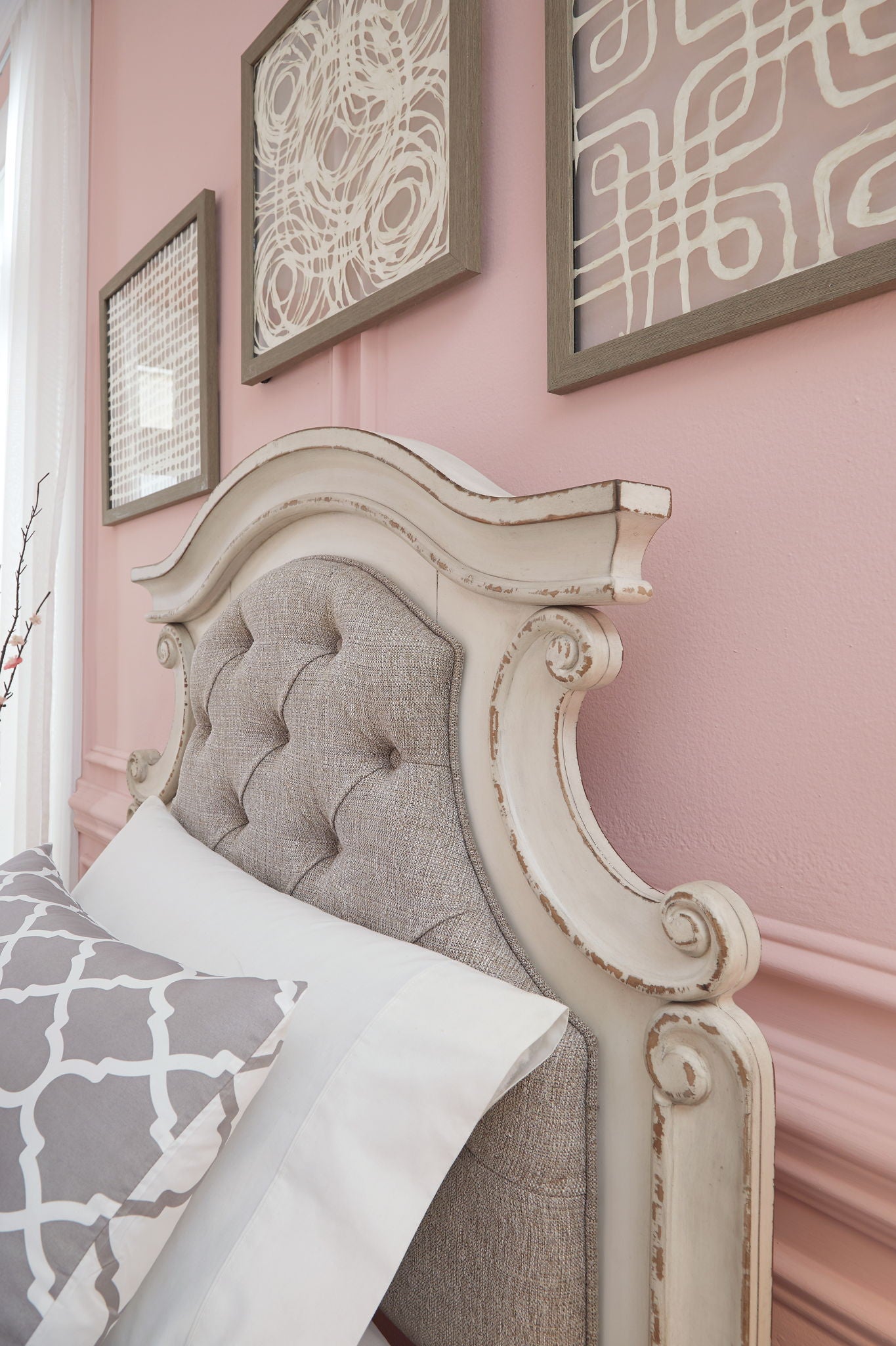Tufted upholstered headboard panel with ornate white wood trim and beige fabric