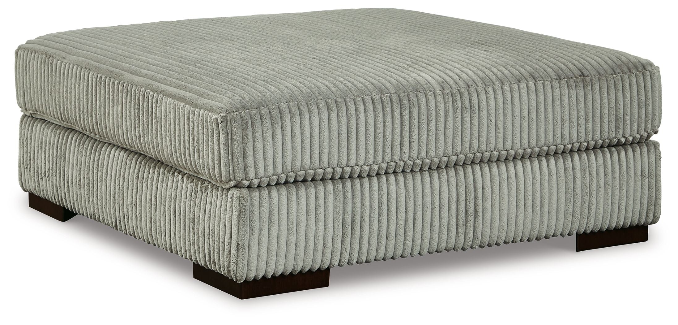Gray oversized ottoman with ribbed fabric cover and square padded top on dark legs