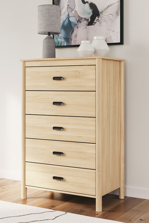 Tan five-drawer chest with black bar pulls and light wood sides.