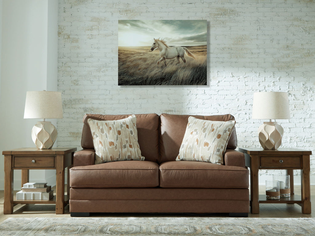 Caramel-brown loveseat with two patterned throw pillows and square arms
