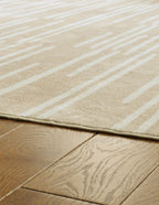 Beige area rug corner with thin border and visible woven texture
