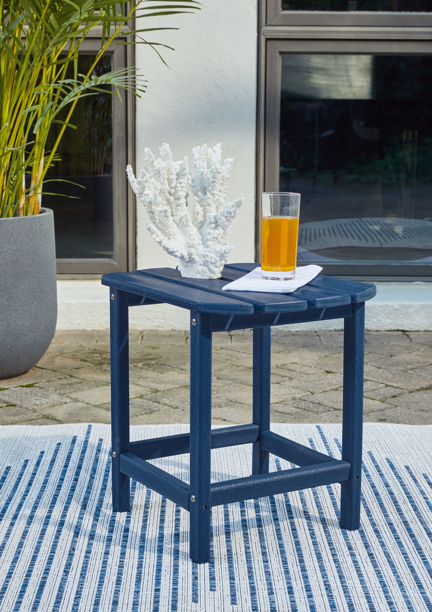Blue outdoor side table with flat top and lower shelf