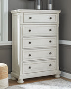 White tall chest of drawers with five drawer fronts and round metal knobs