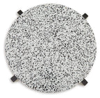 Round accent table top with white speckled surface and black corner pads