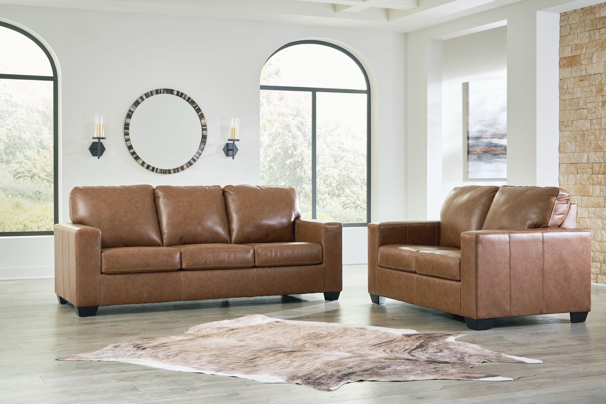 Brown leather sofa and matching armchair with padded seats and square arms