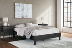Platform bed with white mattress and dark frame, pillows and blanket visible