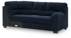 Navy upholstered sofa with corner wedge, tufted back, rounded arm and three seat cushions