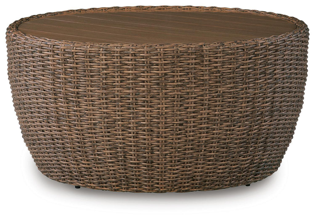 Beige woven round cocktail table with flat top and wicker frame