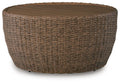 Beige woven round cocktail table with flat top and wicker frame