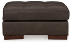 Dark brown upholstered ottoman with tufted top, thick base, exposed wooden feet