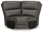 Upholstered wedge seat in dark gray with padded arms, backrest, and attached footrest