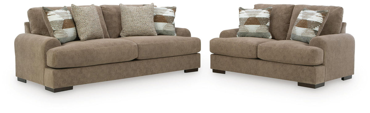 Brown sofa and loveseat set with patterned and solid throw pillows