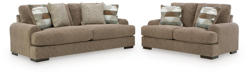 Brown sofa and loveseat set with patterned and solid throw pillows
