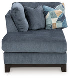Navy corner chaise sofa with plush chaise seat, tufted back, geometric pillow, dark legs