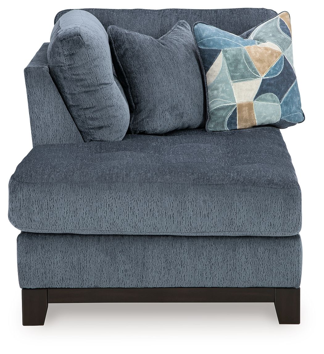 Navy corner chaise sofa with plush chaise seat, tufted back, geometric pillow, dark legs