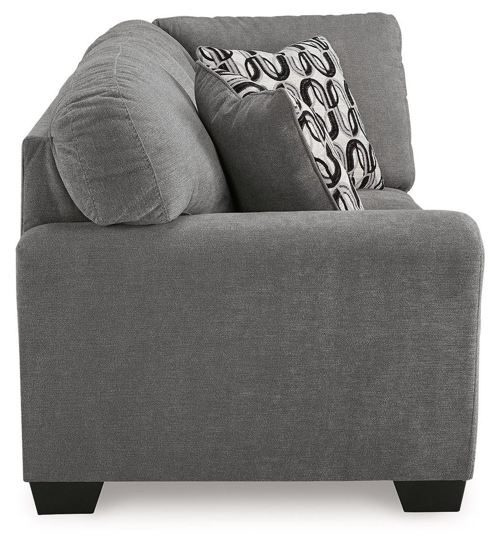 Gray corner wedge sofa chaise with rounded arms and patterned back throw pillow