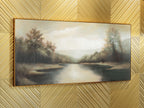 Framed wide river landscape painting with autumn-toned trees and cloudy light sky