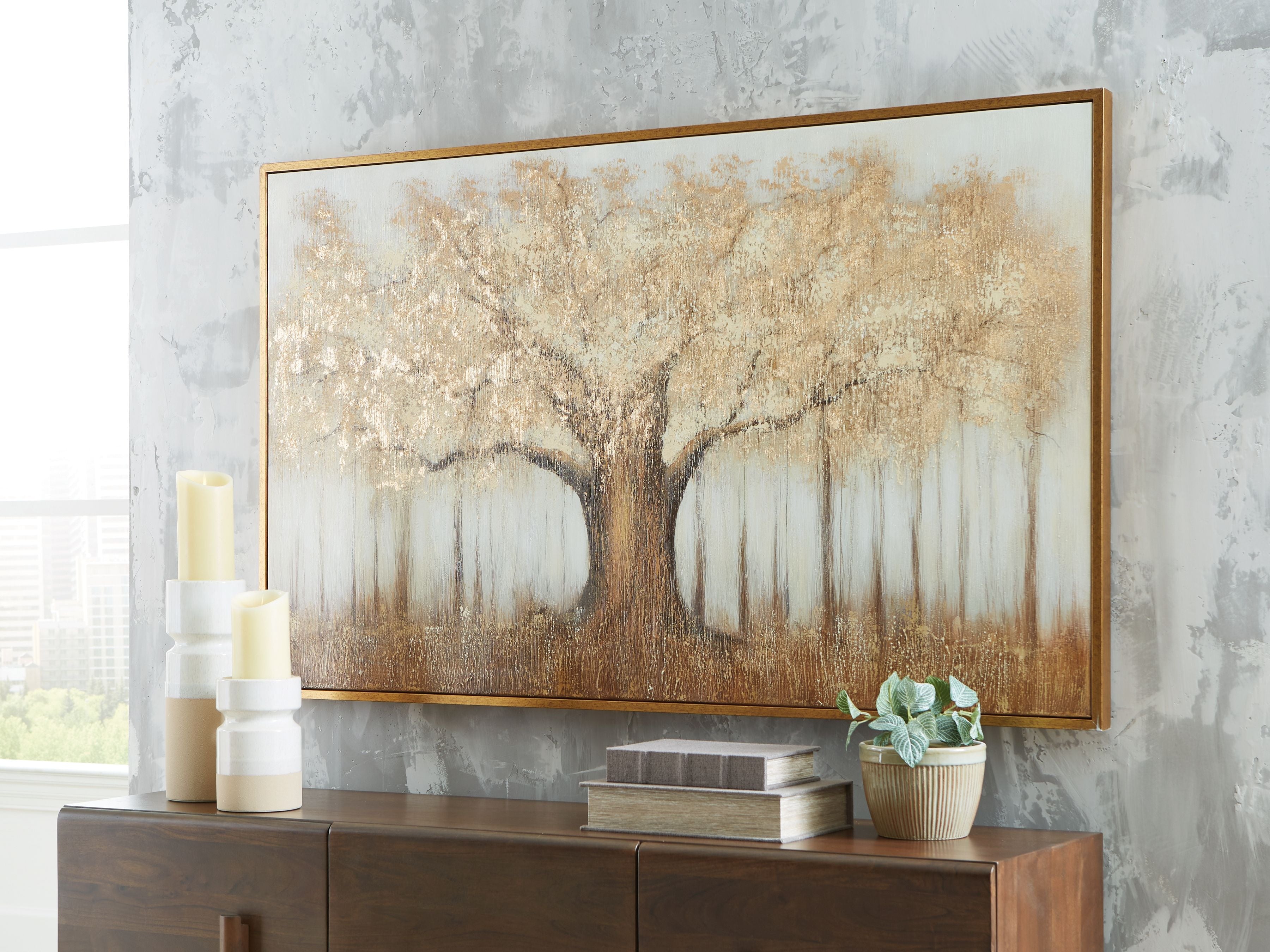 Framed wall art featuring a tree silhouette with white hanging forms on warm background