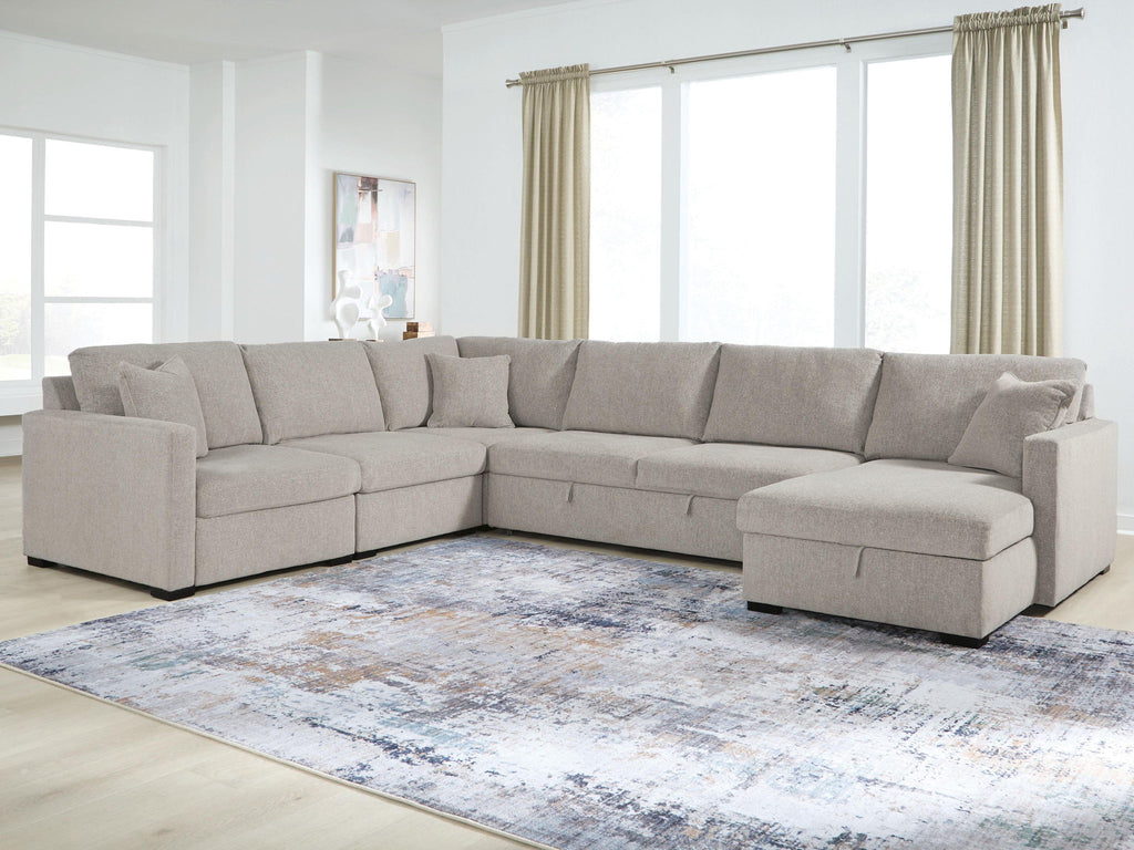 Gray sectional sofa with chaise corner and wide seat cushions with layered back pillows