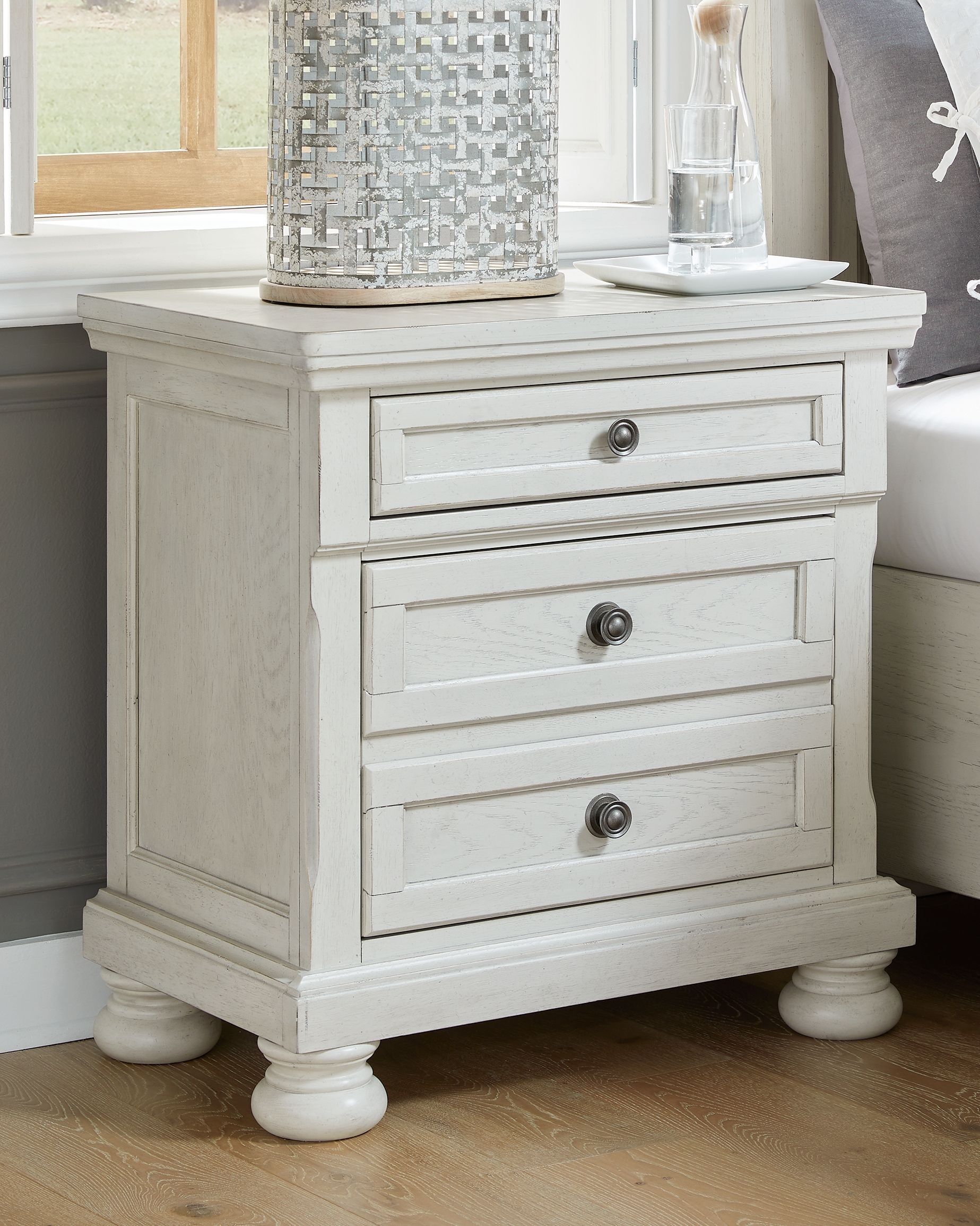 Antique white nightstand with two drawers and round metal pulls, paneled sides