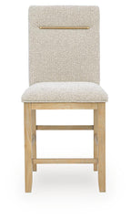 Upholstered barstool with light brown textured upholstery, wooden legs, brass bar