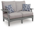 Gray loveseat with seat cushion and two blue floral throw pillows