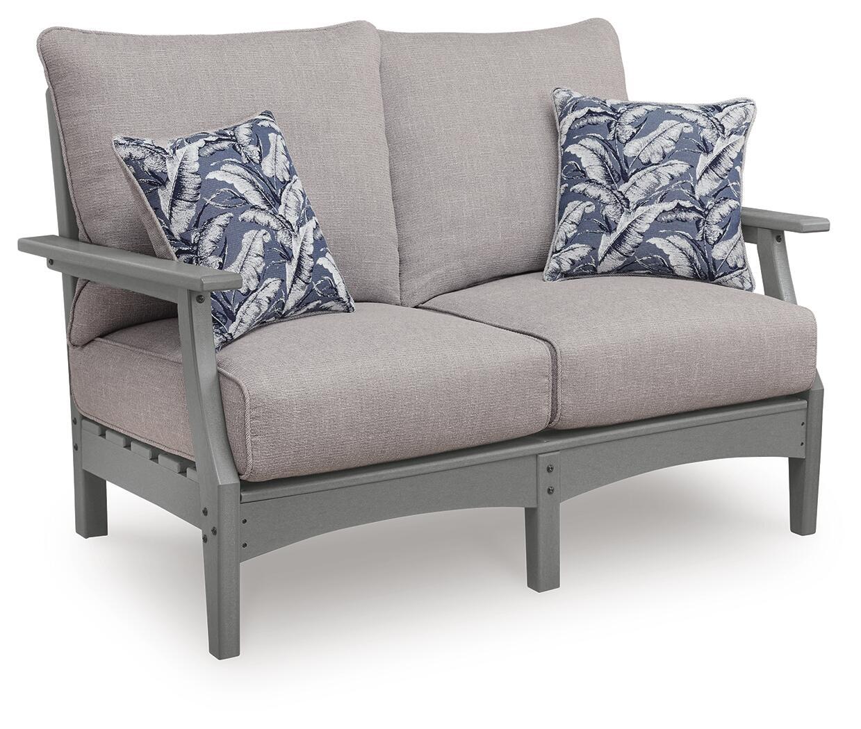Gray loveseat with seat cushion and two blue floral throw pillows