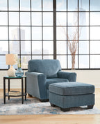 Blue upholstered armchair with matching ottoman in front