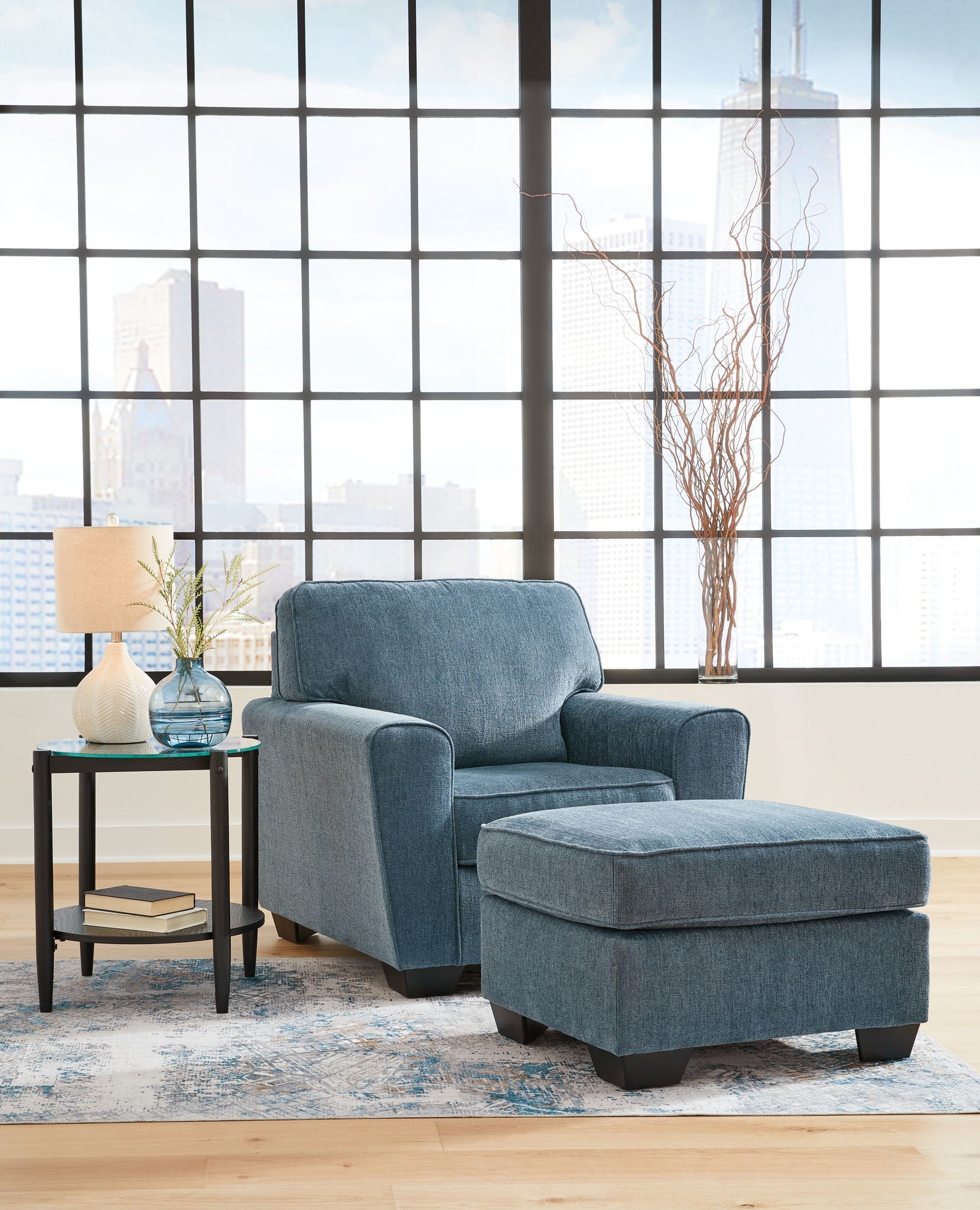 Blue upholstered armchair with matching ottoman in front