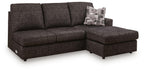 Dark charcoal sofa chaise with tufted cushions and two accent pillows