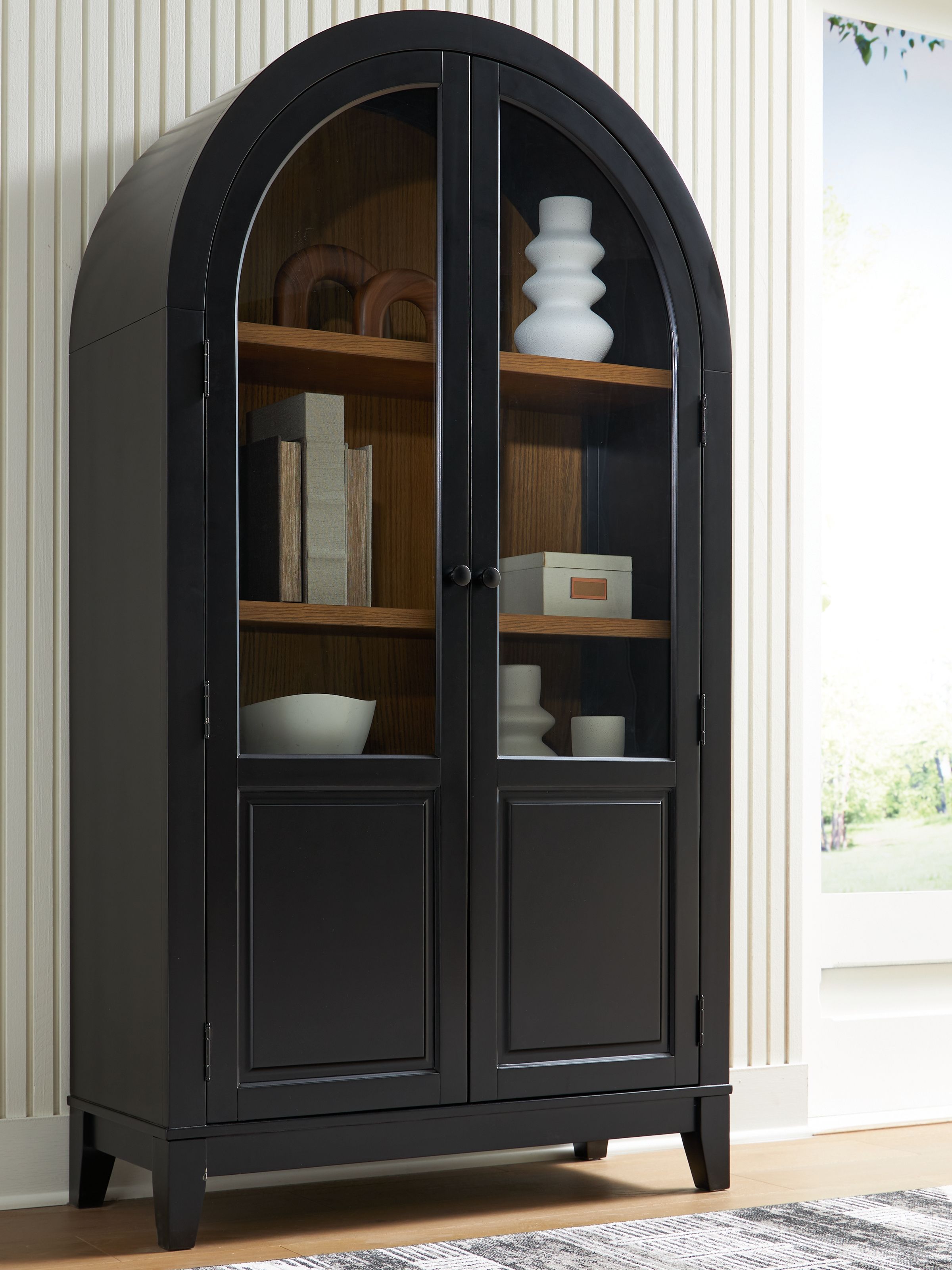 Black accent cabinet with arched glass doors and multiple interior shelves