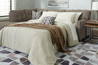 Sofa sleeper opened to a bed with dark gray backrest and layered throw pillows
