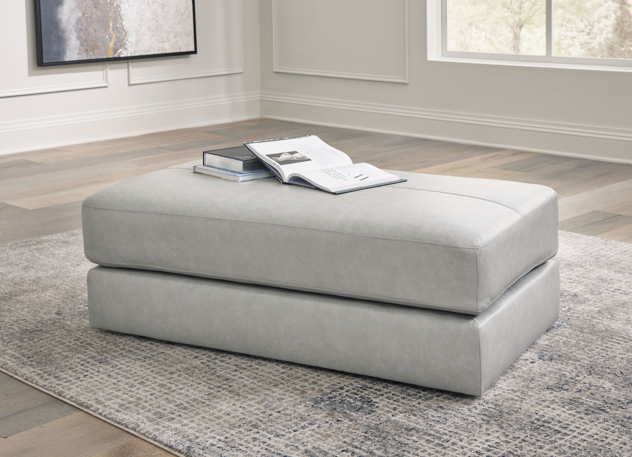 Light gray oversized ottoman with wide top cushion and low, rectangular base