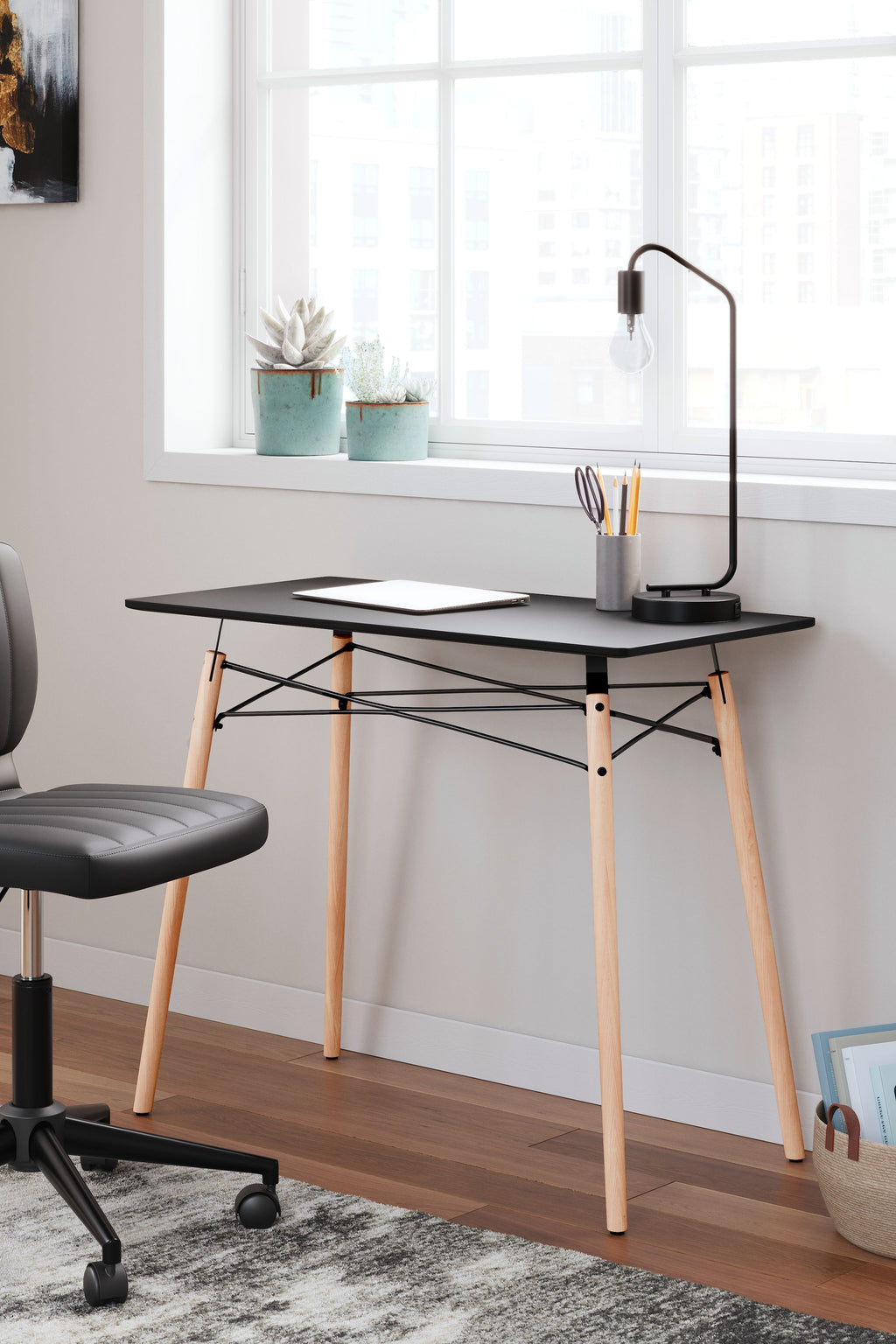 Jaspeni home office desk with black tabletop and light wood legs, black cross-braced support