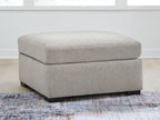 Upholstered ottoman with wide seat and square base, light gray fabric, dark legs