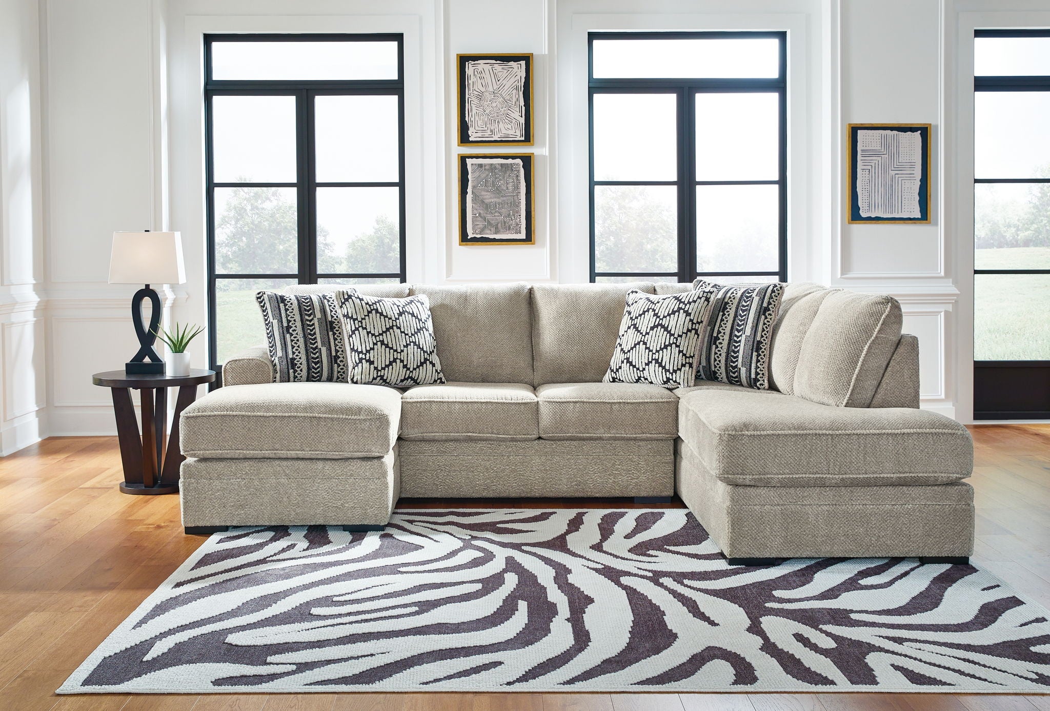 Beige corner chaise sectional sofa with patterned throw pillows and two chaise ottomans