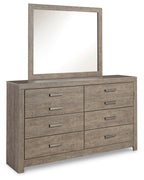 Gray dresser with square mirror and six drawers, each with brushed metal handles.