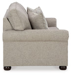 Queen sofa sleeper with light gray upholstery, tufted arms, and two accent pillows