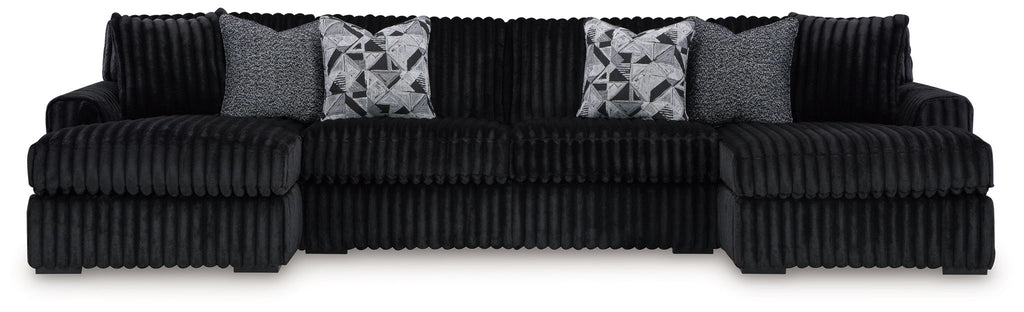 Black corded sectional sofa with chaise and gray patterned throw pillows