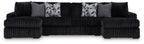 Black corded sectional sofa with chaise and gray patterned throw pillows