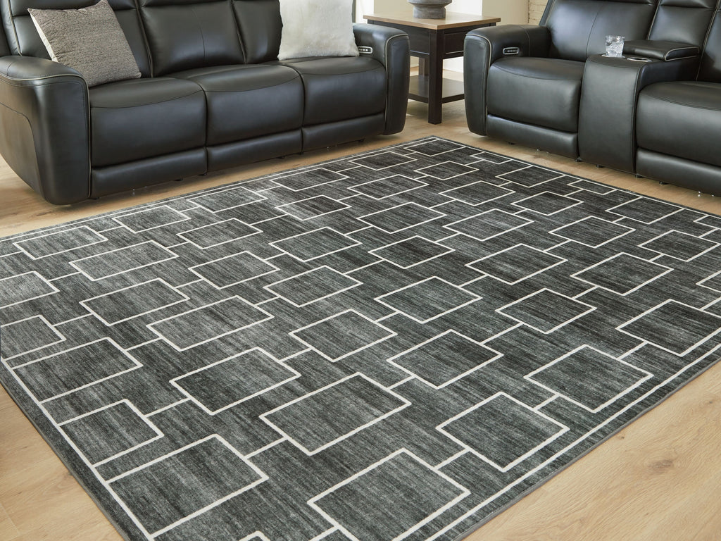 Elderland washable rug laid on wood floor with dark gray and white geometric design
