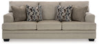 Sofa sleeper in light taupe fabric with two geometric throw pillows and three seat cushions