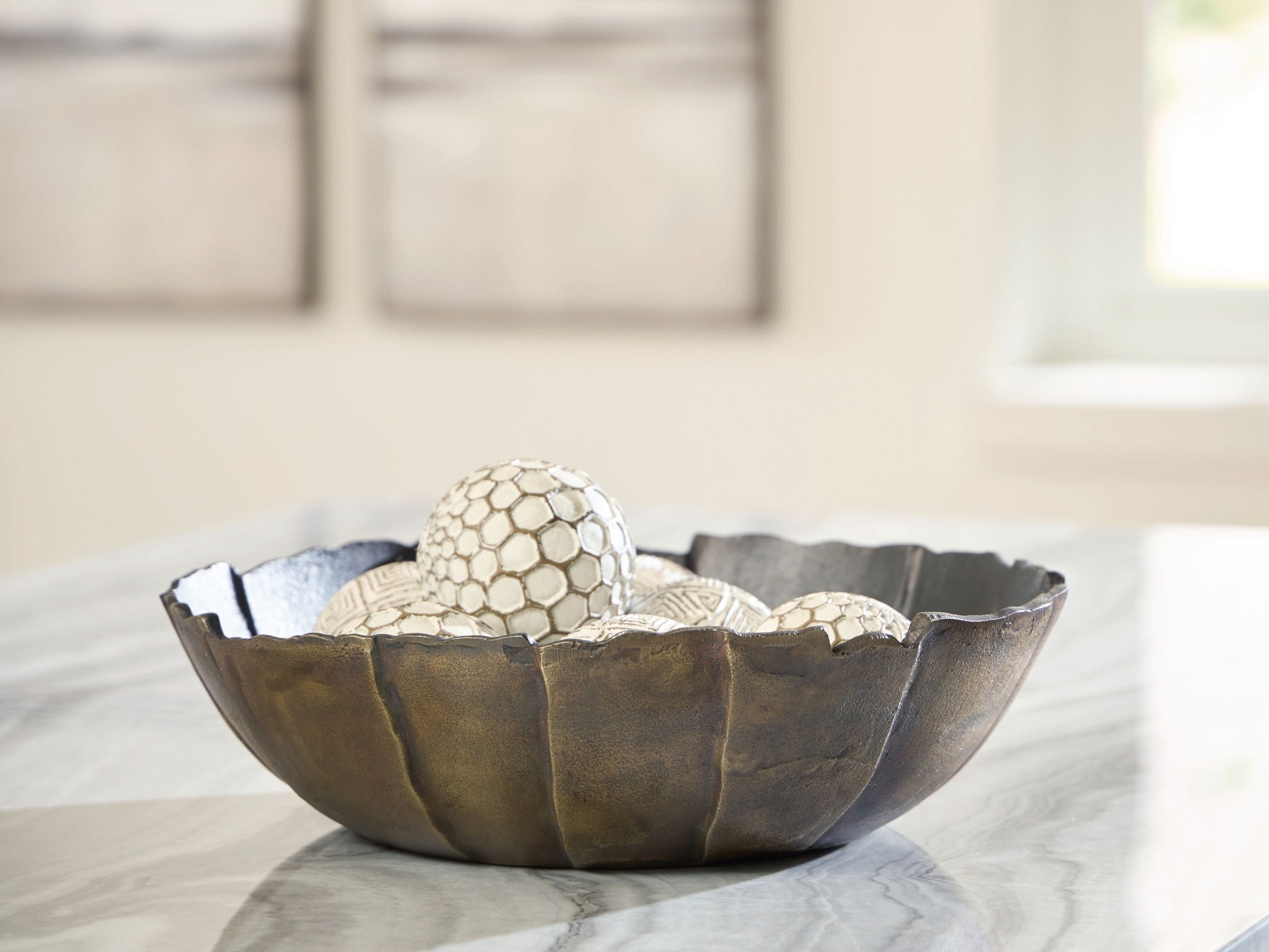 Metal decorative bowl with scalloped rim, dark interior and honeycomb sphere finial