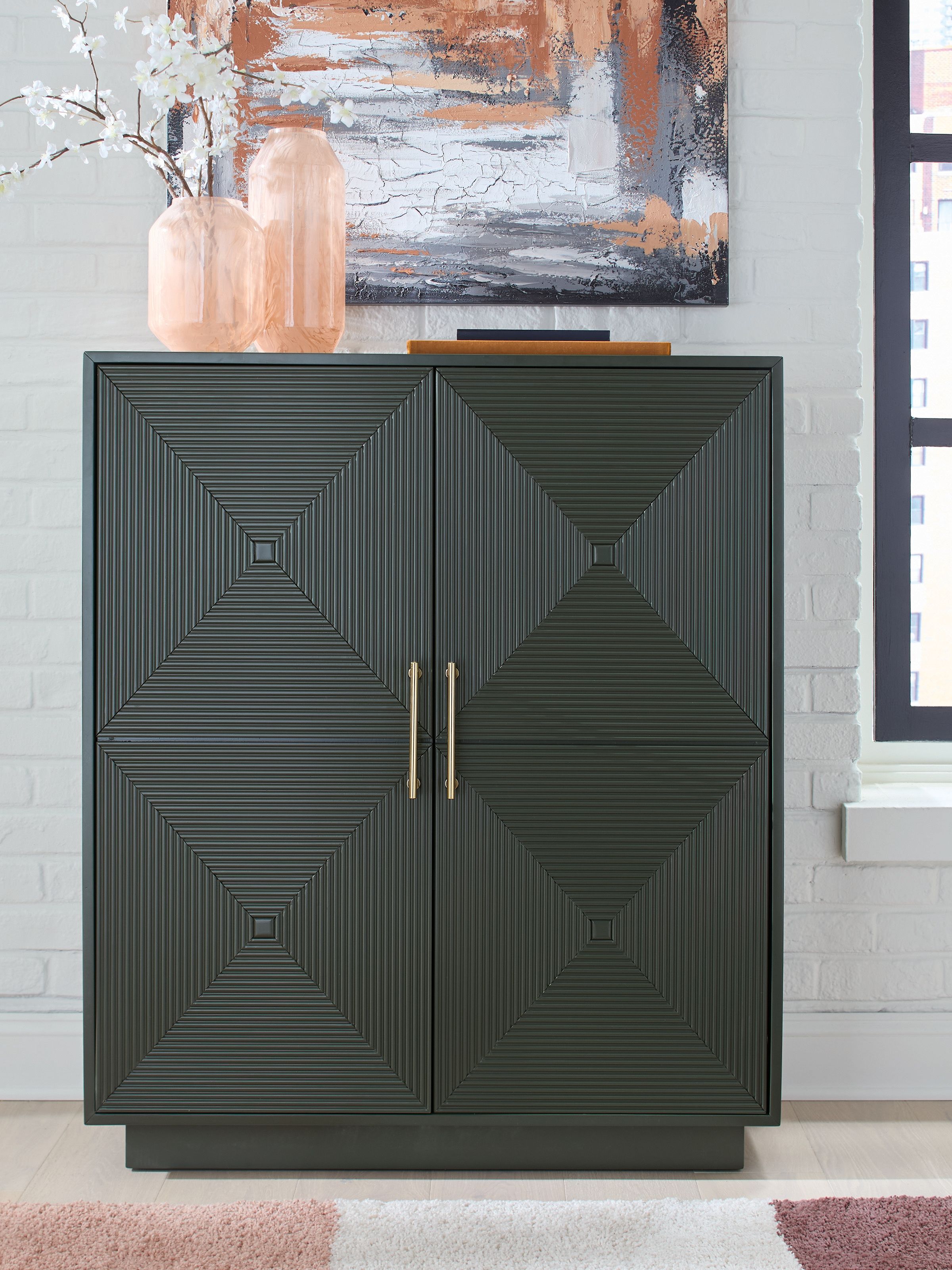 Dark green accent cabinet with geometric door panels and brass-tone double handles